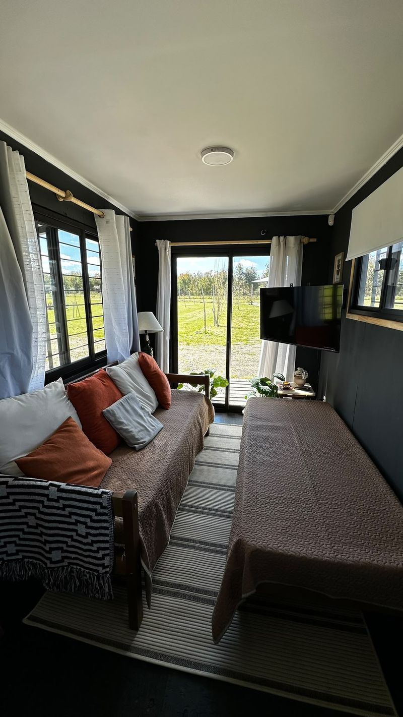Living de Las Glicinas con ventanal al campo