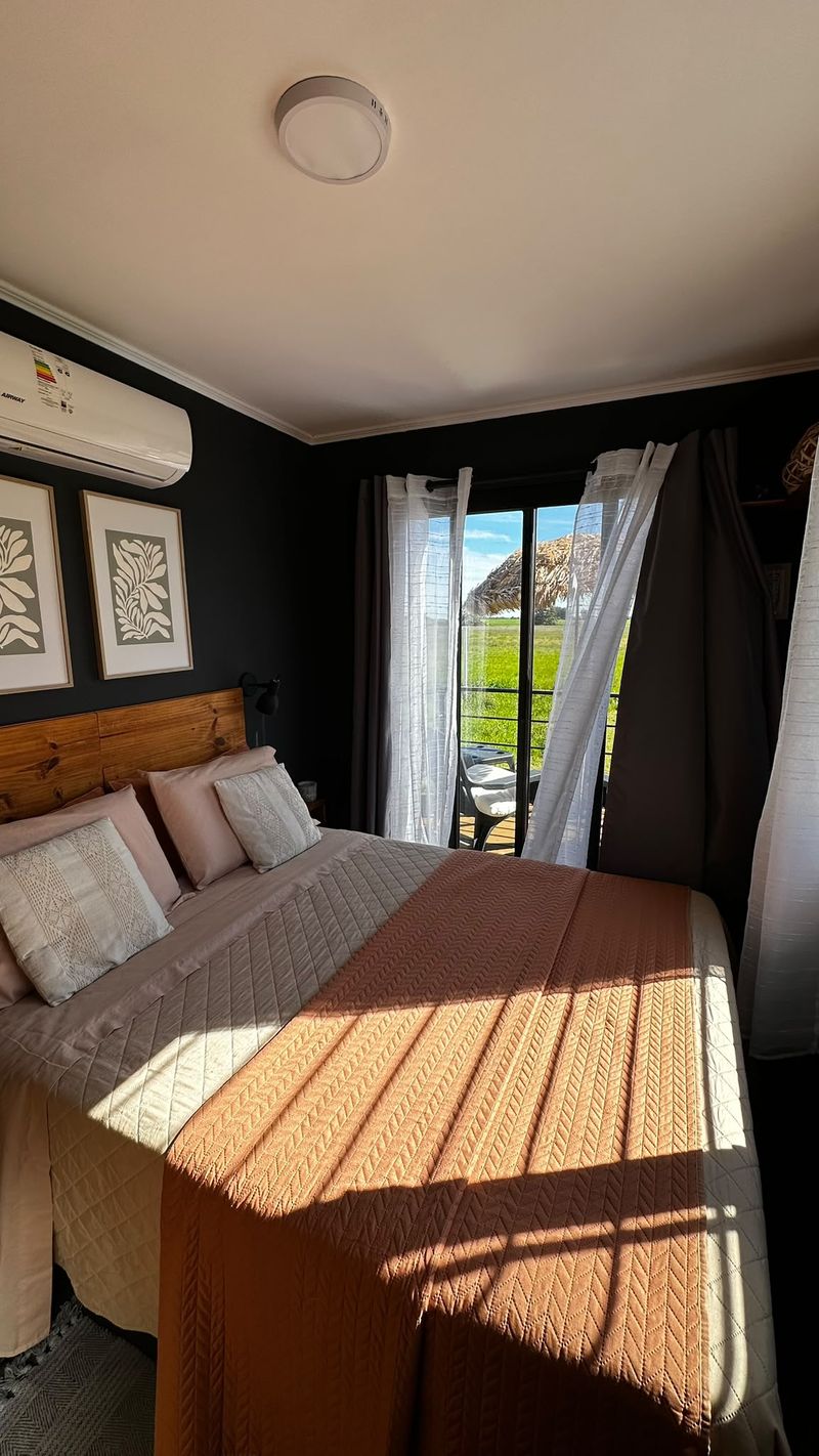 Dormitorio con aire acondicionado y vista a la terraza